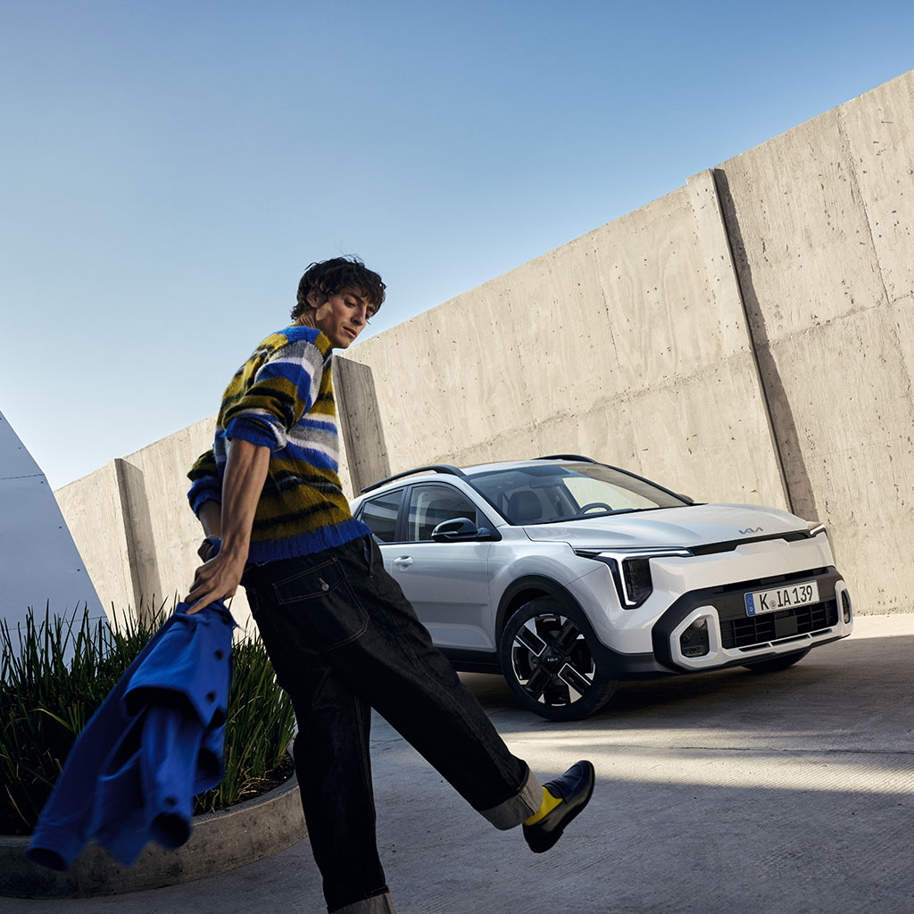 Kia Stonic mit einem Model an einer Wand.
