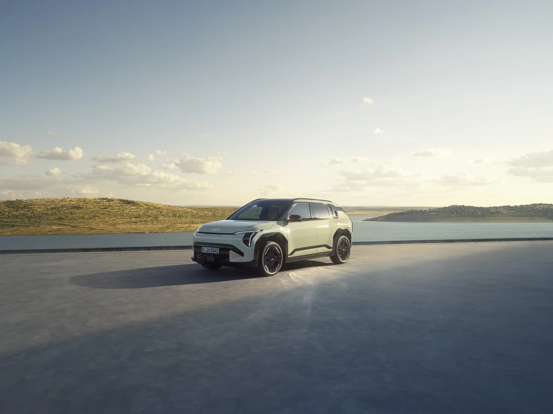 Kia EV3 GT-line in Mattgrün auf einer Küstenstraße