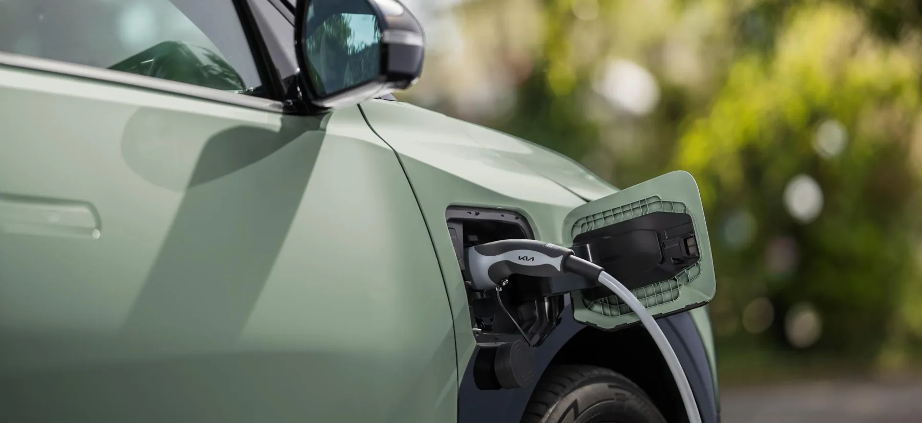 Geöffnete Ladeklappe des Kia EV3 mit eingestecktem Ladekabel