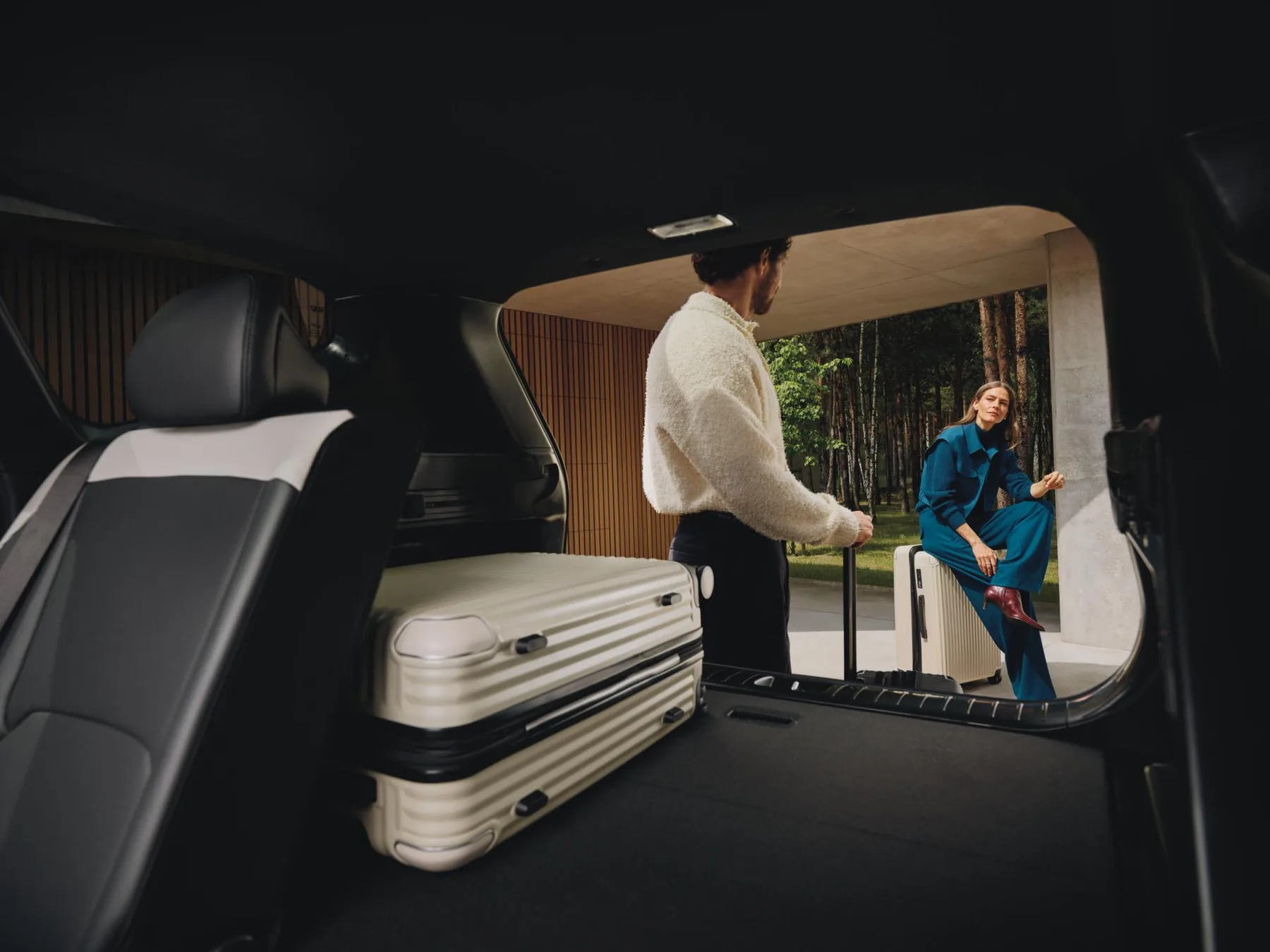 Paar belädt den Kofferraum des Kia EV5 GT-line mit einem Koffer