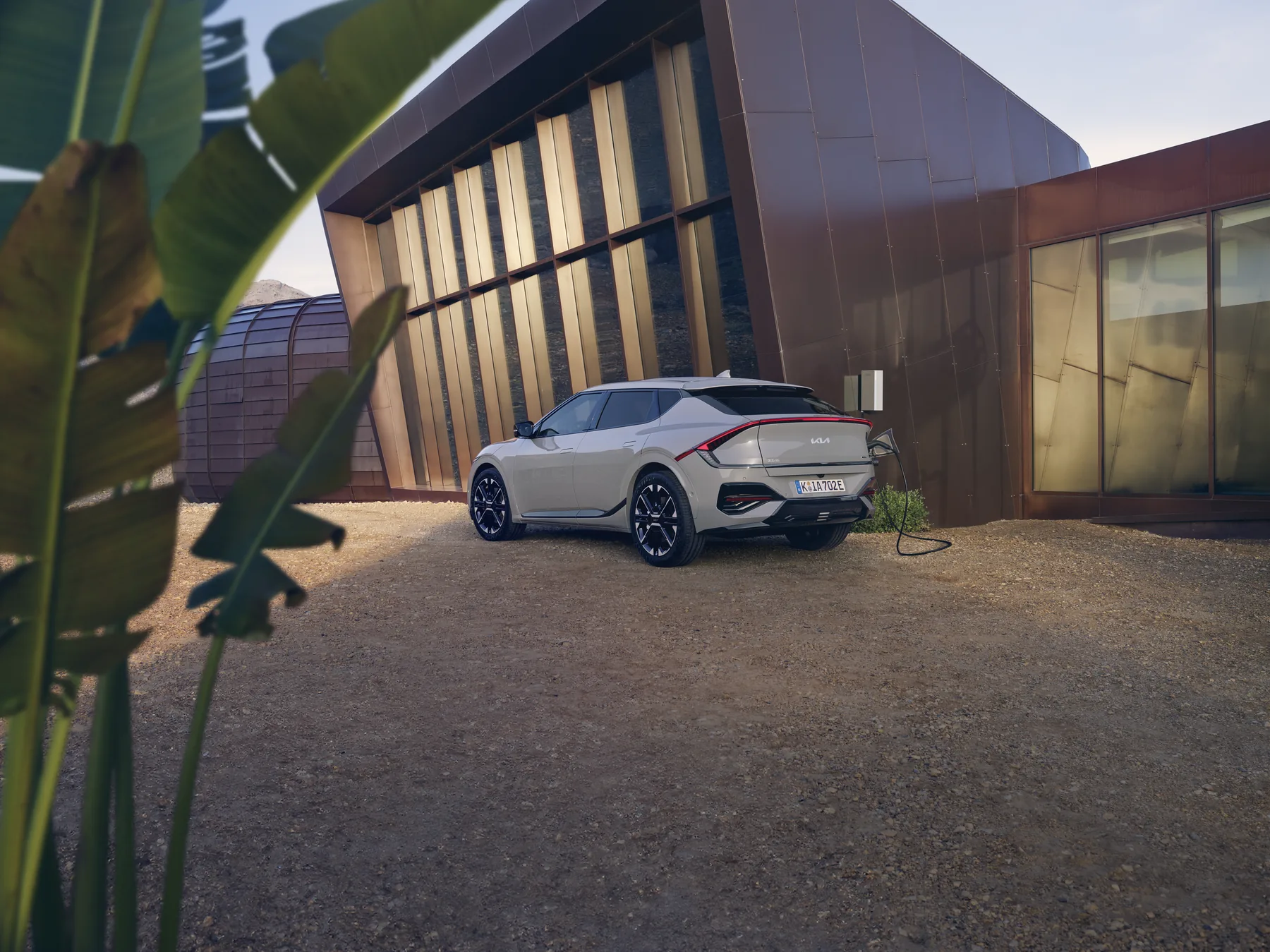 Kia EV6 GT-line lädt an der heimischen Wallbox, Ansicht von schräg hinten