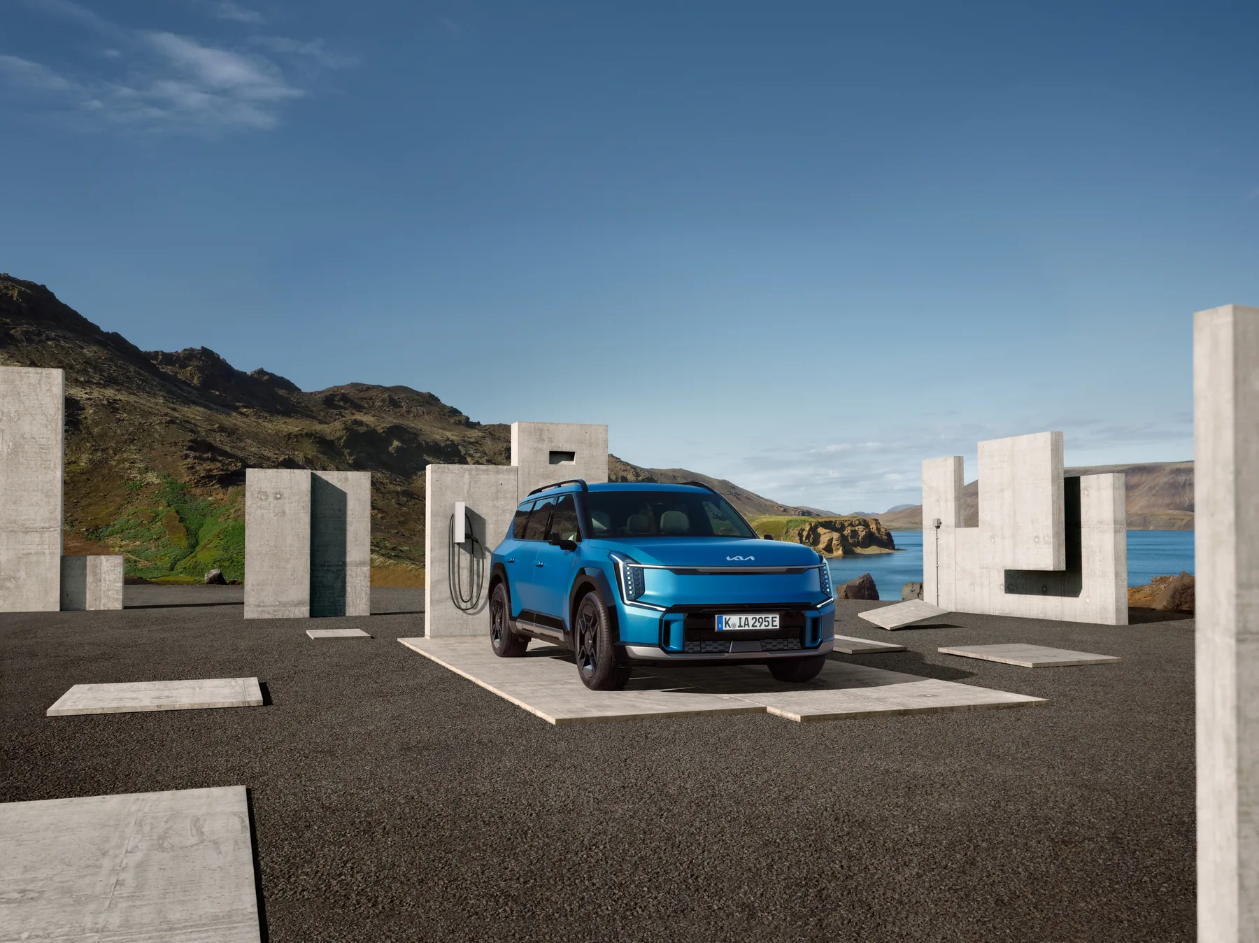 Kia EV9 in Blau zwischen Betonstelen in einer Küstenlandschaft