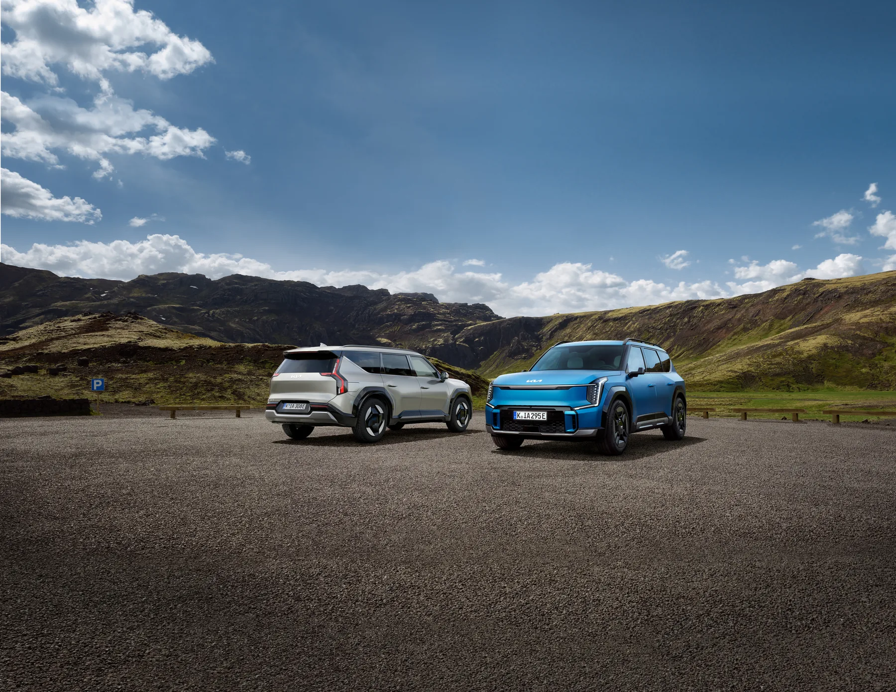 Zwei Kia EV9 in unterschiedlichen Ausführungen vor einer Berglandschaft