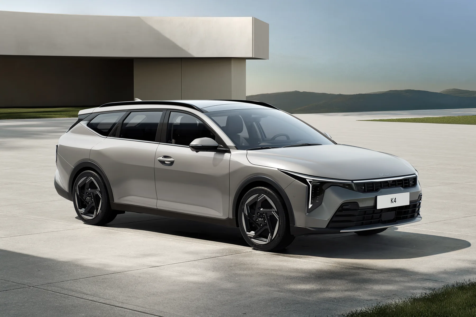 Kia K4 Sportswagon in Silber, Dreiviertelansicht von vorn vor heller Architektur