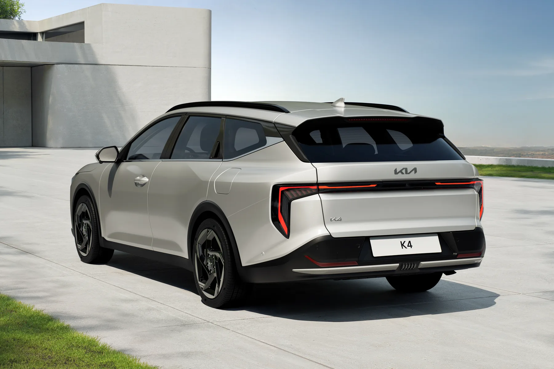 Kia K4 Sportswagon in Silber, Dreiviertelansicht von hinten mit durchgehendem Leuchtenband