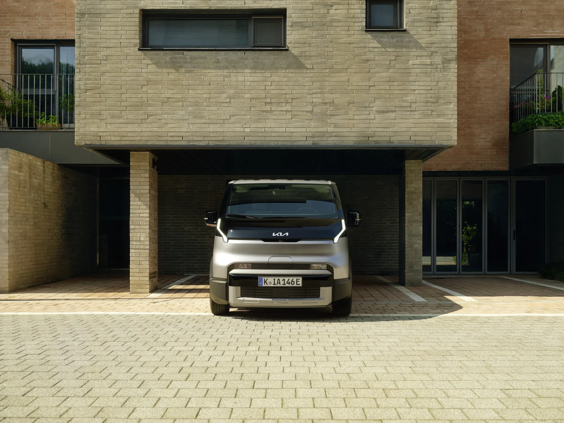 Kia PV5 Cargo in der Frontansicht unter einem Gebäudeüberhang