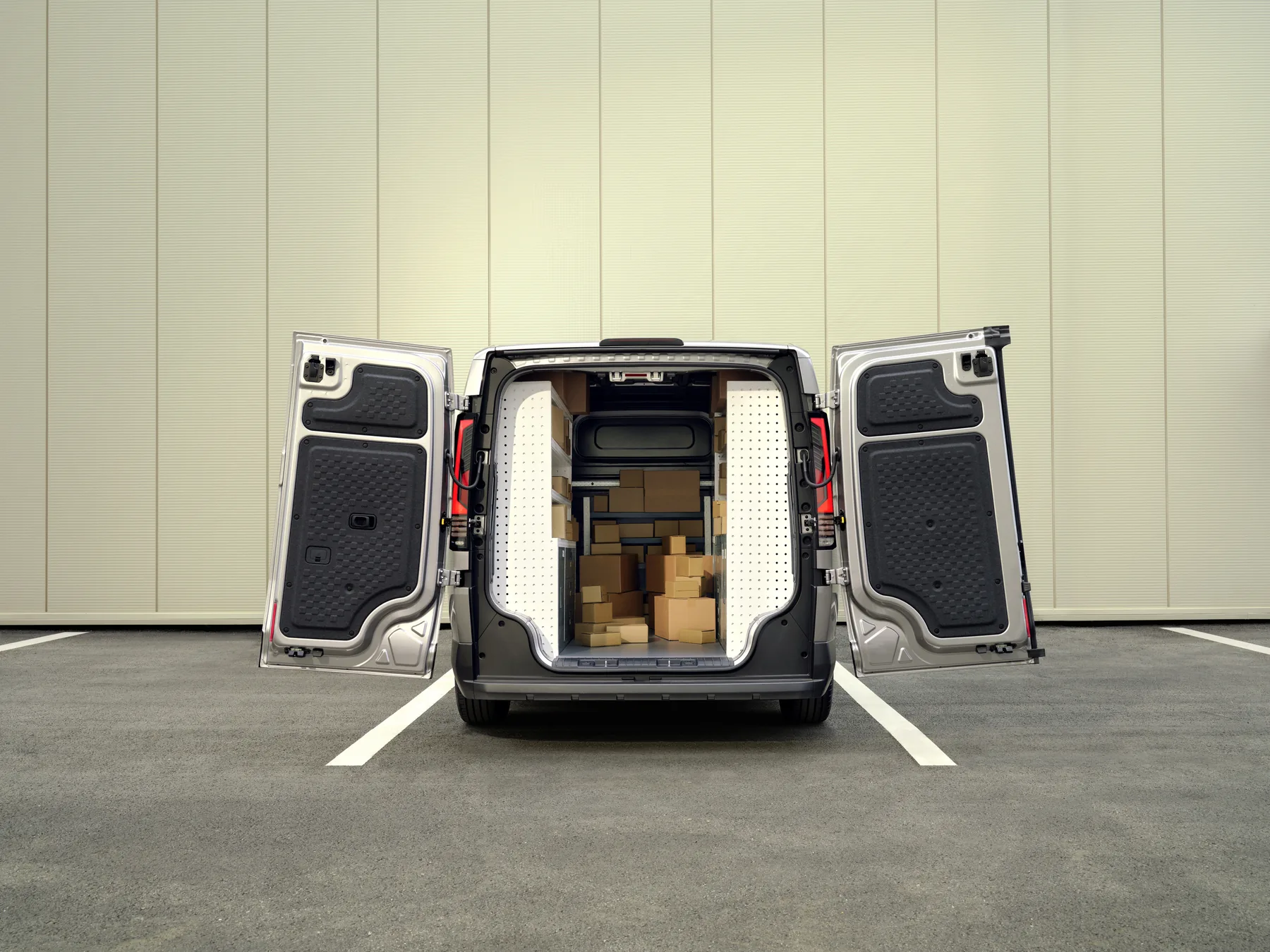 Kia PV5 Cargo mit geöffneten Hecktüren und beladenem Laderaum