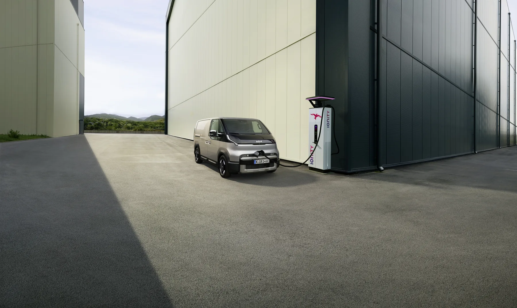 Kia PV5 Cargo lädt an einer Ladesäule auf dem Betriebshof