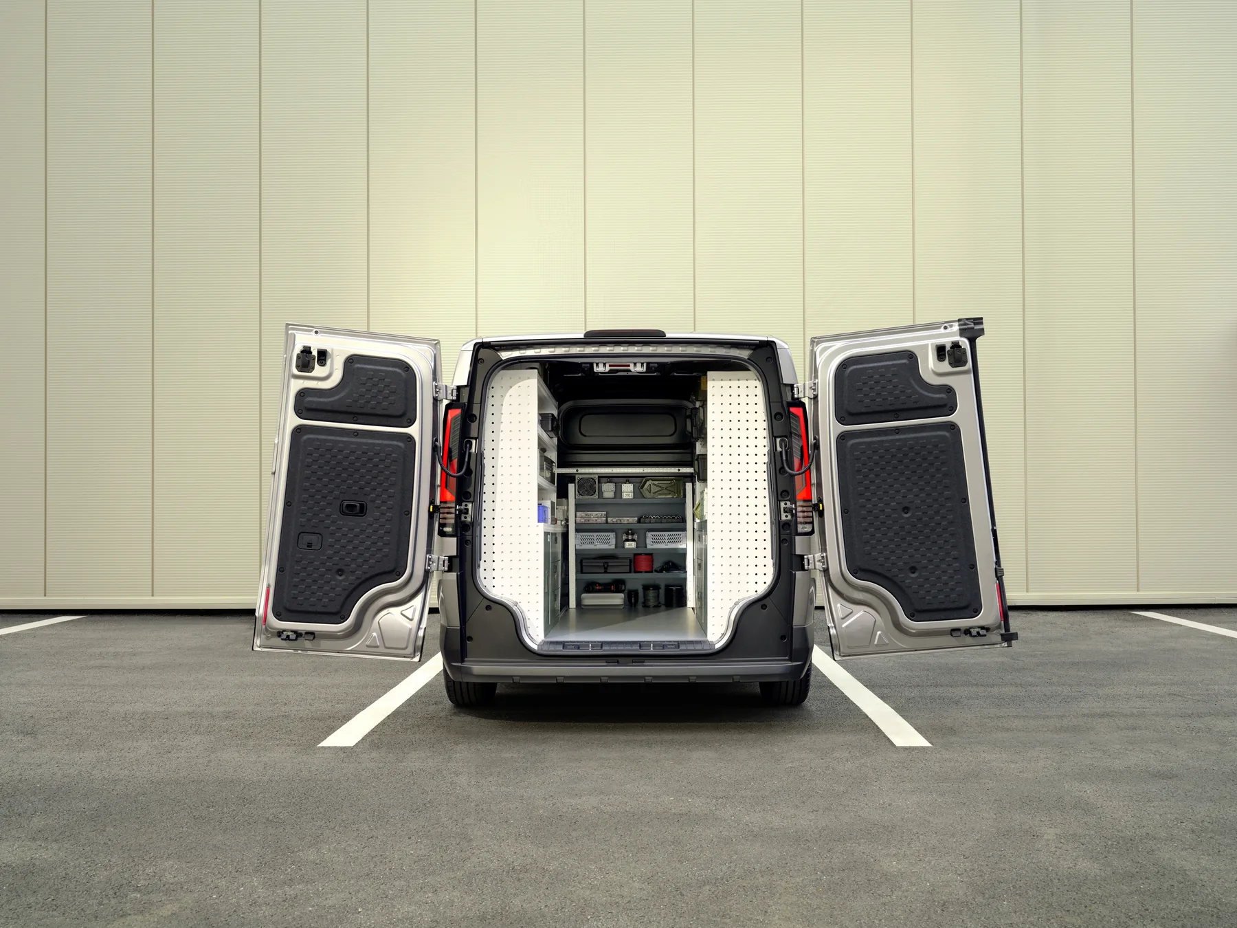 Kia PV5 Cargo mit Regaleinbau im Laderaum bei geöffneten Hecktüren