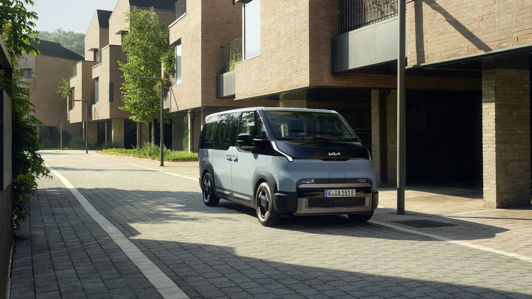 Kia PV5 Passenger in Hellblau in einer Wohnstraße, Dreiviertelansicht von vorn